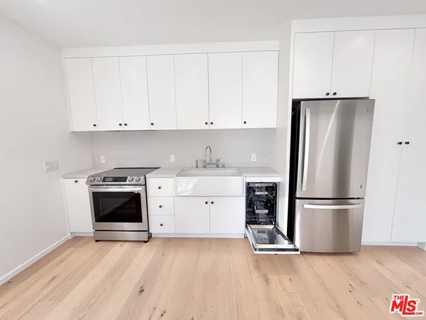 a kitchen with a refrigerator stove and white cabinets
