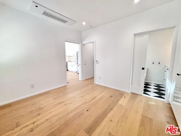 a view of an empty room with wooden floor