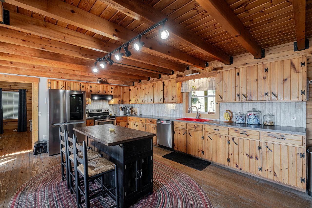 12012 Hollar School Road Linville, VA 22834 - Photo 37 of 75 a kitchen with granite countertop a sink a counter space stainless steel appliances and cabinets