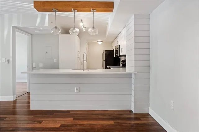 a view of a kitchen with wooden floor and a ceiling fan