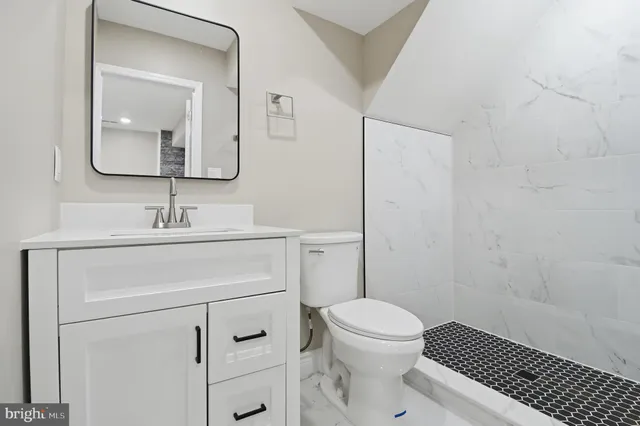 a bathroom with a sink toilet vanity and shower