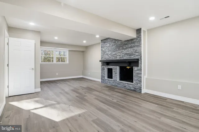an empty room with wooden floor and fireplace