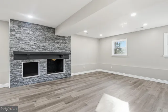 a view of empty room with wooden floor and fireplace