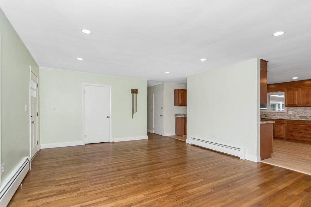49 Parham Road Tyngsborough, MA 01879 - Photo 6 of 31 a view of an empty room with wooden floor and a kitchen