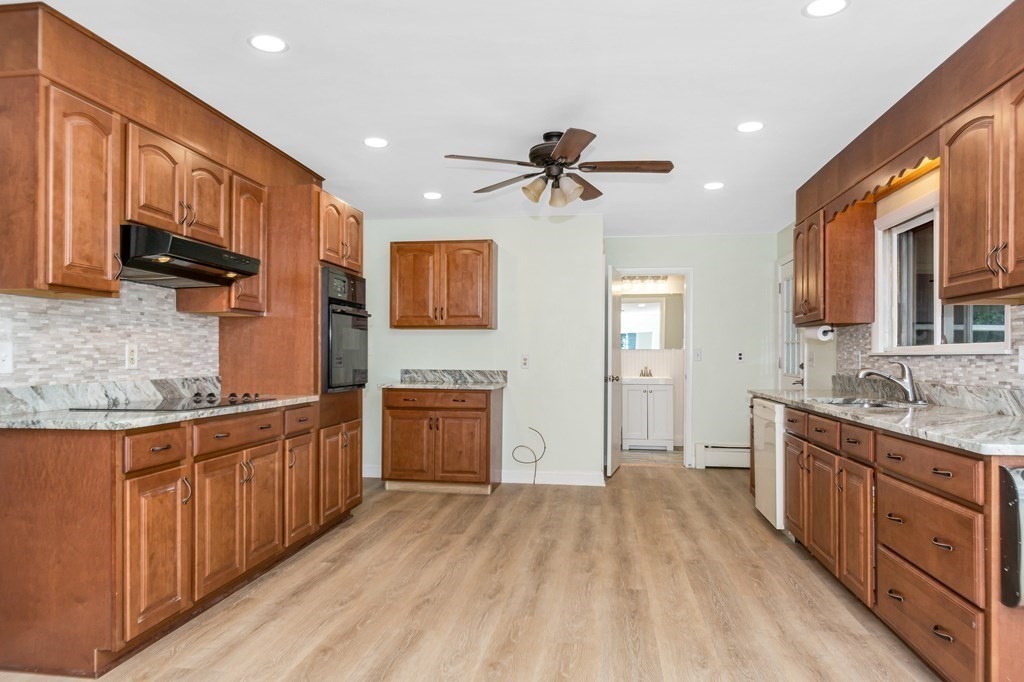49 Parham Road Tyngsborough, MA 01879 - Photo 8 of 31 a open kitchen with stainless steel appliances granite countertop a refrigerator a stove top oven a sink dishwasher and wooden cabinets with wooden floor