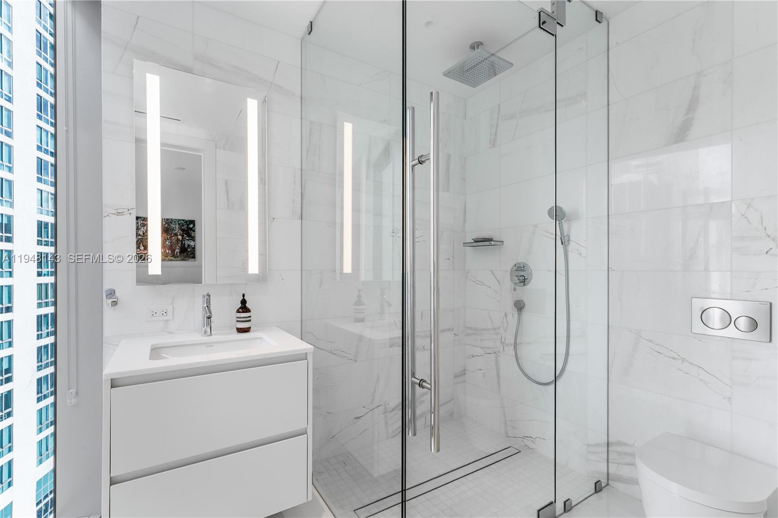 300 Biscayne Blvd Way, Unit 2102 Miami, FL 33131 - Photo 52 of 80 a bathroom with a shower sink and mirror
