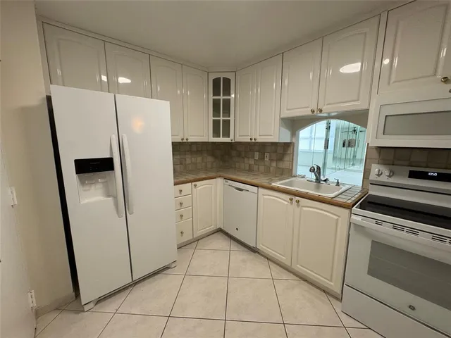 a kitchen with granite countertop a sink and cabinets