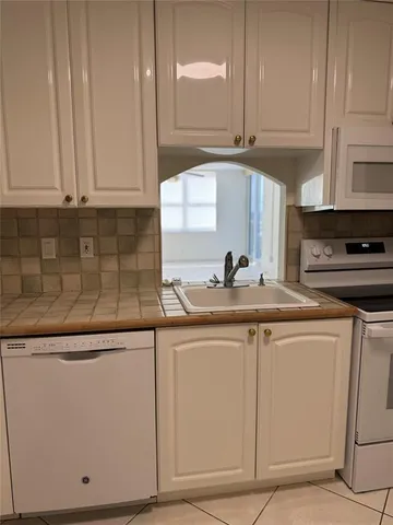 a white refrigerator freezer sitting inside of a kitchen
