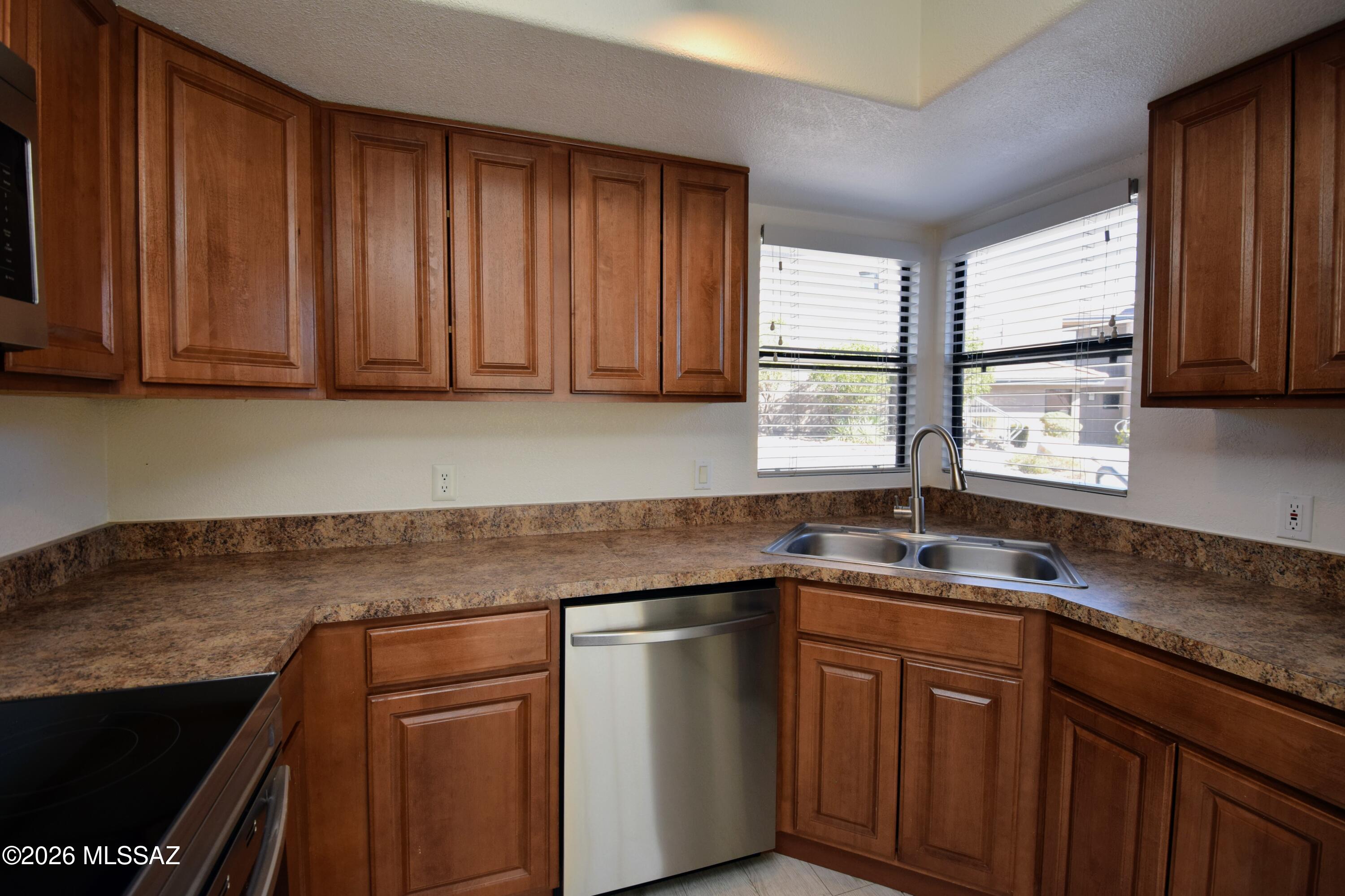 5855 North Kolb Road, Unit 11106 Tucson, AZ 85750 - Photo 13 of 36 a kitchen with stainless steel appliances granite countertop cabinets sink and window