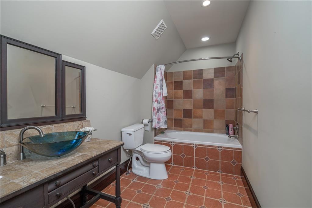 723 Sulphur Springs Road Southeast Fairmount, GA 30139 - Photo 30 of 54 a bathroom with a granite countertop sink a toilet a mirror and shower