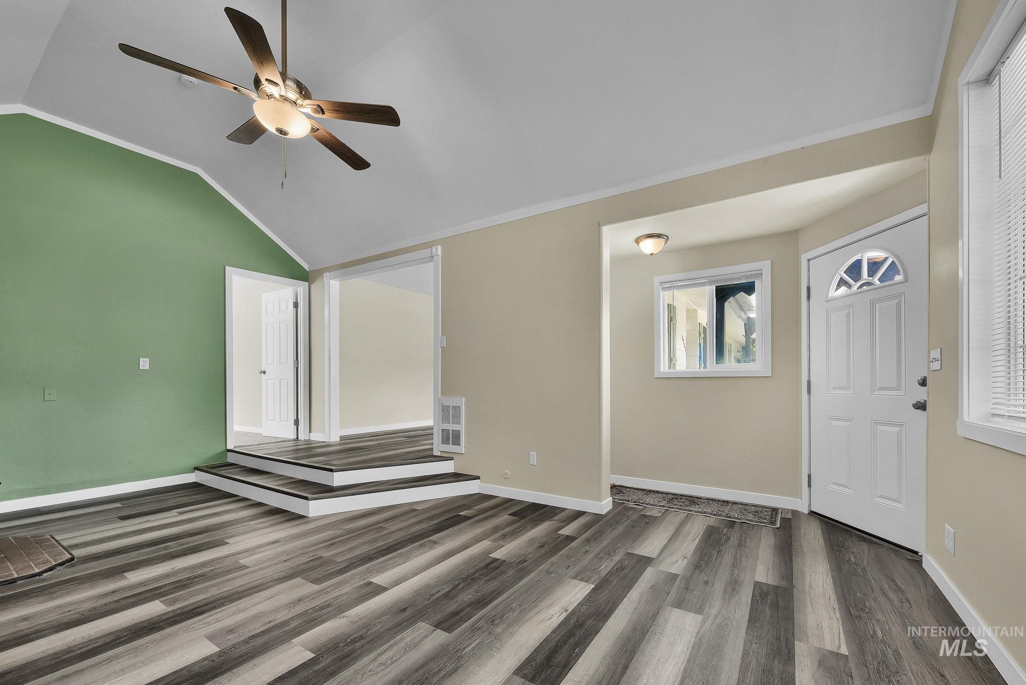 5755 Chuckwagon Road Nampa, ID 83686 - Photo 6 of 50 Vaulted ceiling with a ceiling fan, wood-finish flooring, two-step platform, white paneled doors, and an arched transom window above the entry