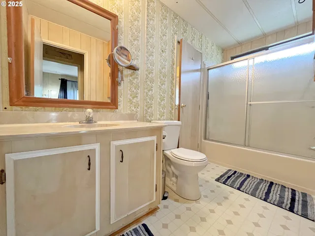 a bathroom with a sink toilet vanity and shower