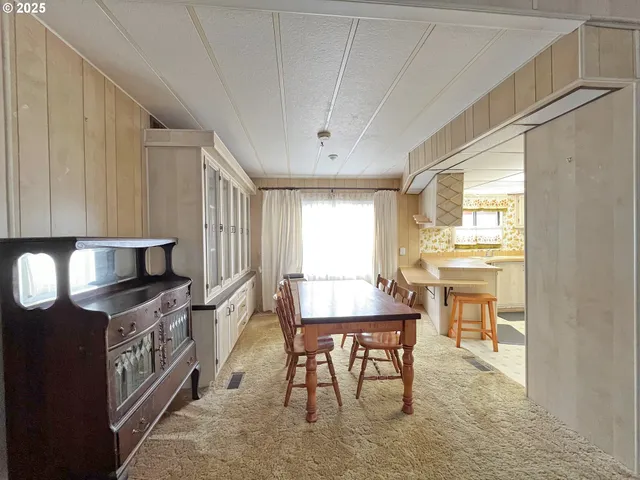 a kitchen with stainless steel appliances granite countertop a stove a sink a dining table and chairs