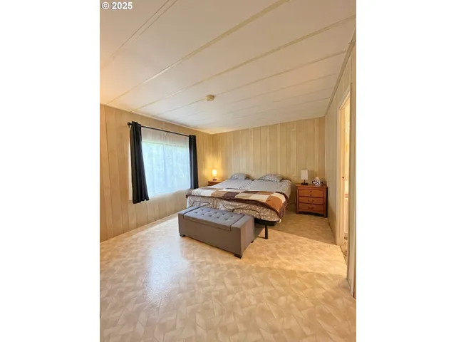 a spacious bedroom with a bed and a window