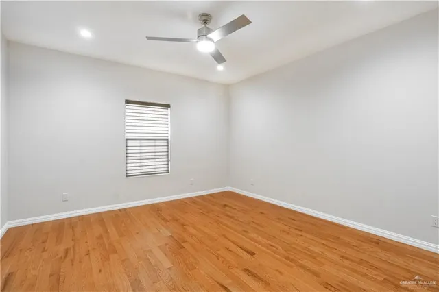 an empty room with a window and a ceiling fan
