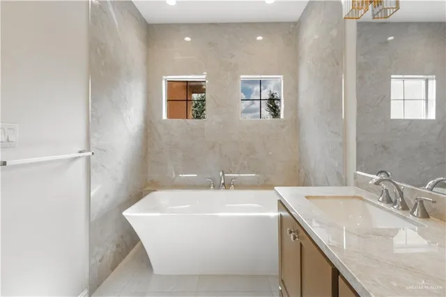 a bathroom with a granite countertop sink a mirror and a shower