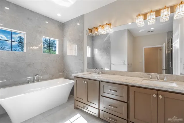 a bathroom with a granite countertop sink mirror and bathtub