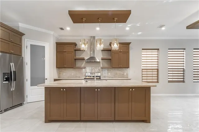 a kitchen with kitchen island granite countertop a sink and refrigerator