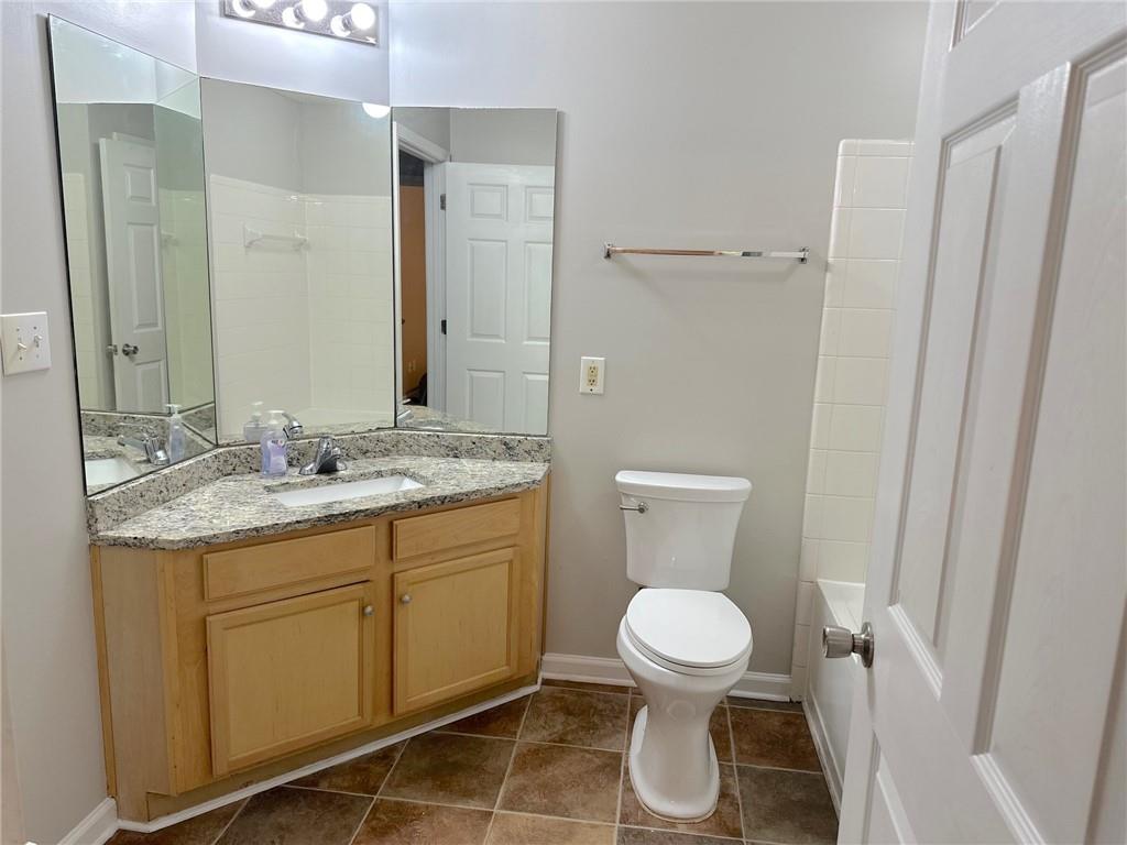 245 Amal Drive Southwest, Unit 2008 Atlanta, GA 30315 - Photo 14 of 23 a bathroom with a granite countertop toilet a sink and a mirror