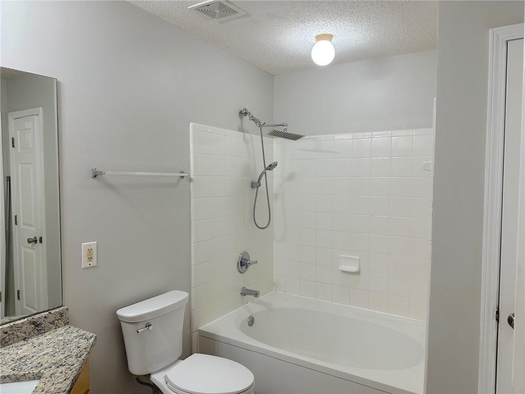 245 Amal Drive Southwest, Unit 2008 Atlanta, GA 30315 - Photo 15 of 23 a bathroom with a granite countertop toilet a sink and bathtub