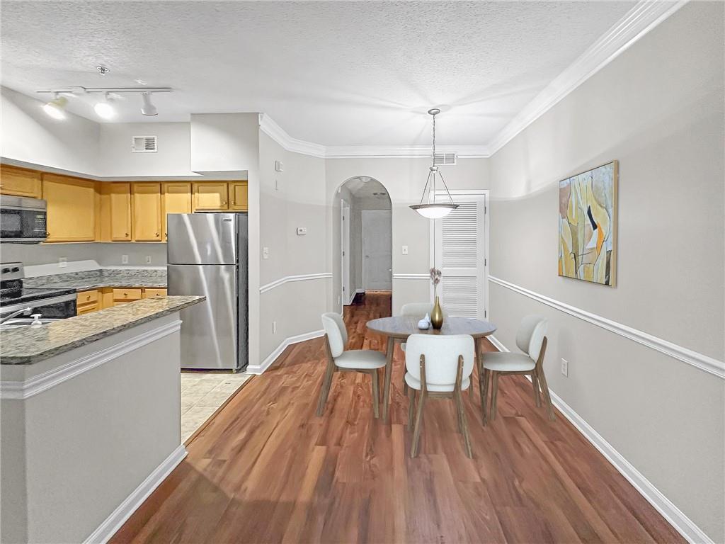 245 Amal Drive Southwest, Unit 2008 Atlanta, GA 30315 - Photo 4 of 23 a dining room with stainless steel appliances furniture a window and wooden floor