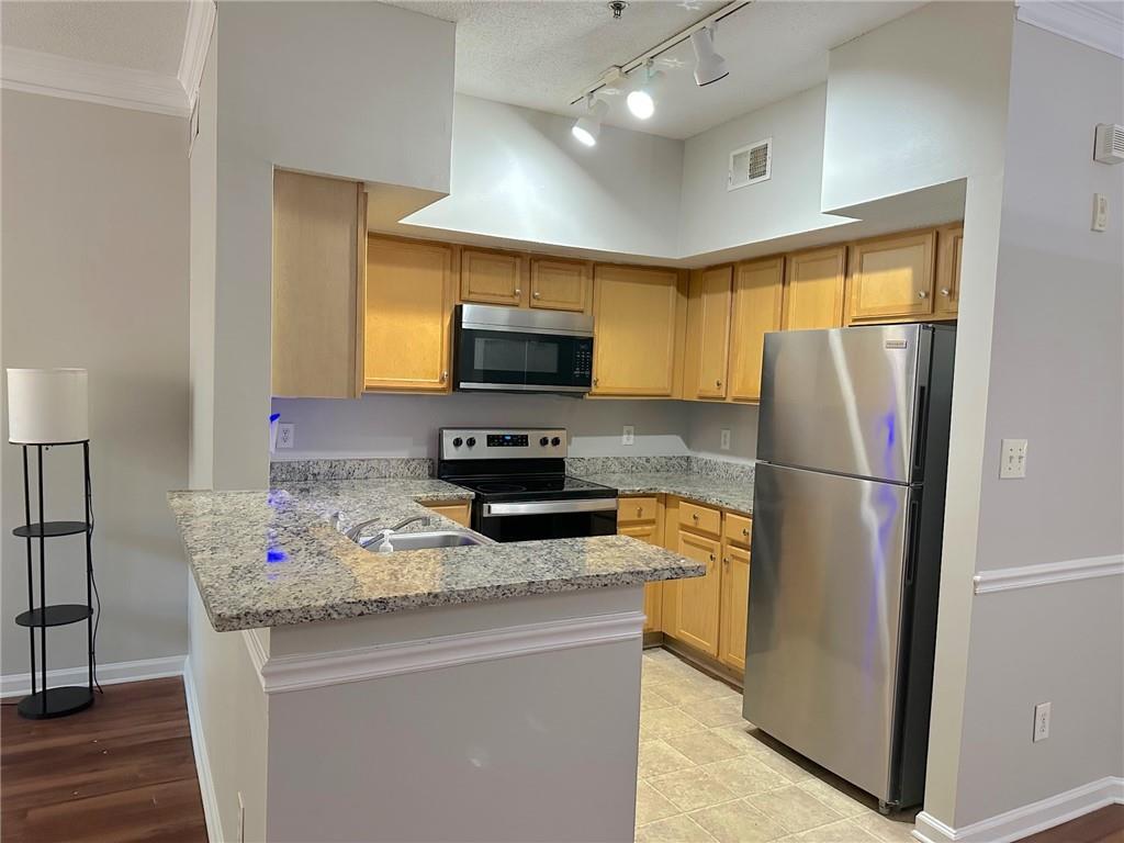 245 Amal Drive Southwest, Unit 2008 Atlanta, GA 30315 - Photo 10 of 23 a kitchen with stainless steel appliances granite countertop a refrigerator a stove a sink a oven with wooden floor