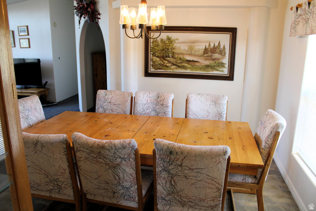 22580 Spring Creek Drive, Unit B61 Fairview, UT 84629 - Photo 16 of 39 Dining area featuring a wood-finish table with seating for eight, a multi-bulb chandelier, and an arched entry to an additional room