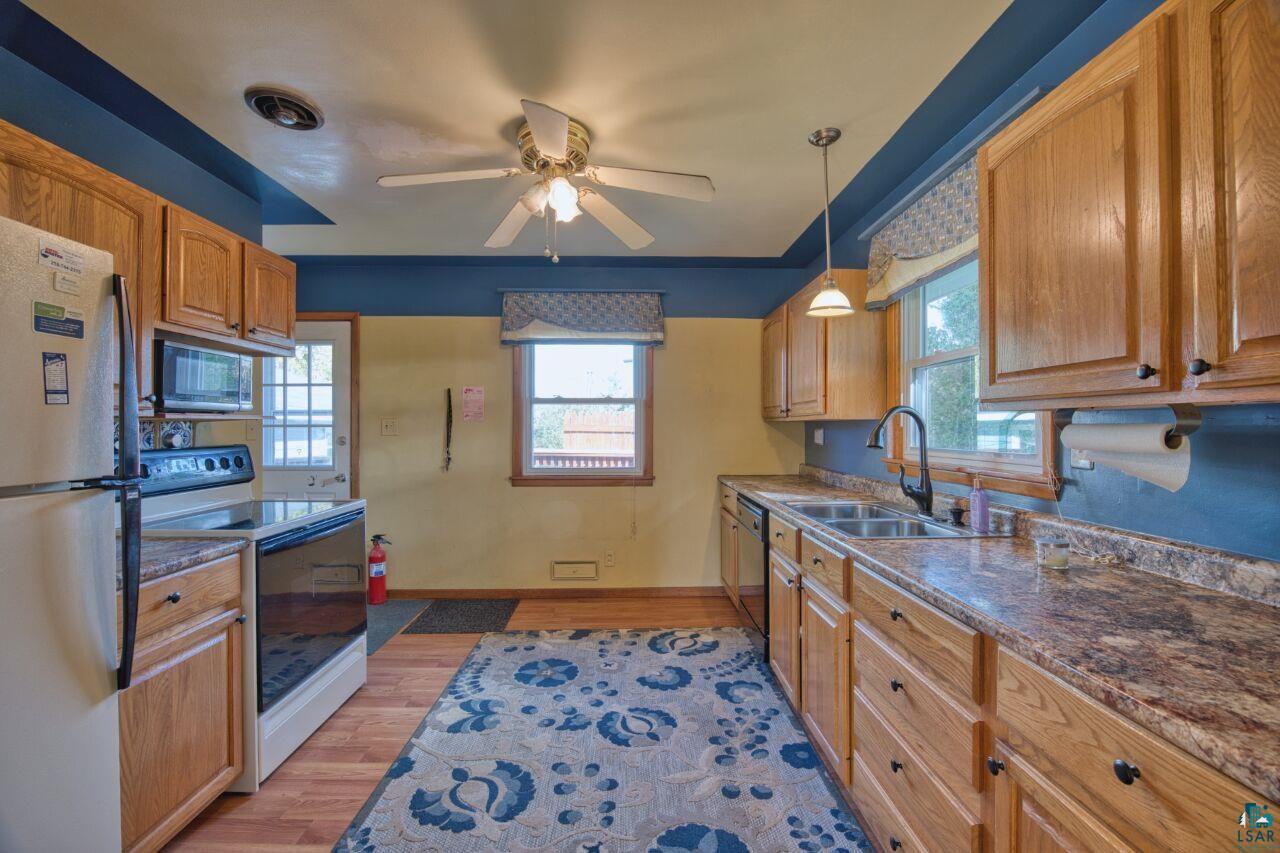 5316 Highway 110 Aurora, MN 55705 - Photo 10 of 35 Kitchen featuring black appliances, light wood-style flooring, hanging light fixtures, and healthy amount of natural light
