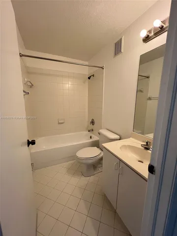 a bathroom with a granite countertop sink toilet a mirror and shower