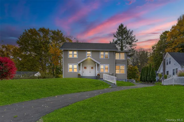 a front view of a house with a yard and trees