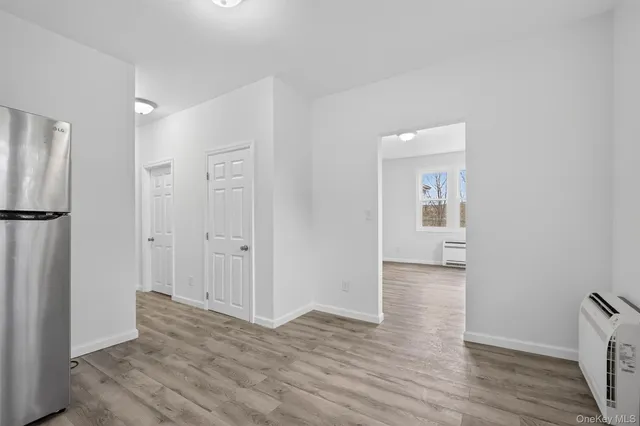a view of a room with wooden floor and a bathroom