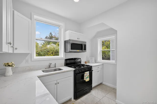 a kitchen with a stove a sink and a window