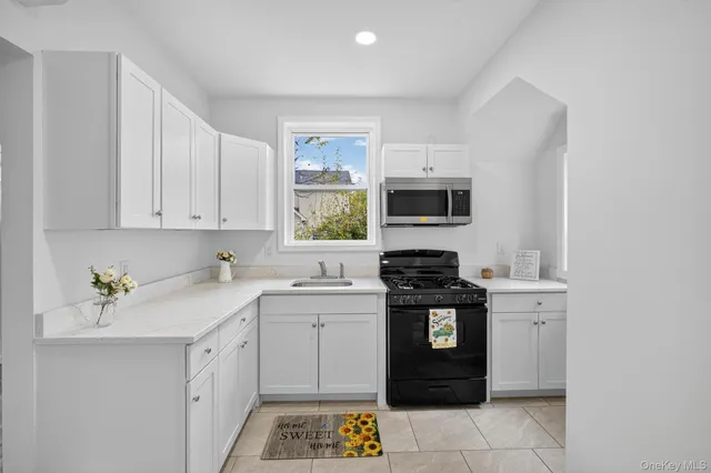 a kitchen with a sink stove and microwave