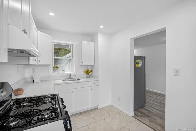 a kitchen with a stove and white cabinets