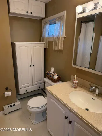 a bathroom with a sink and mirror with toilet