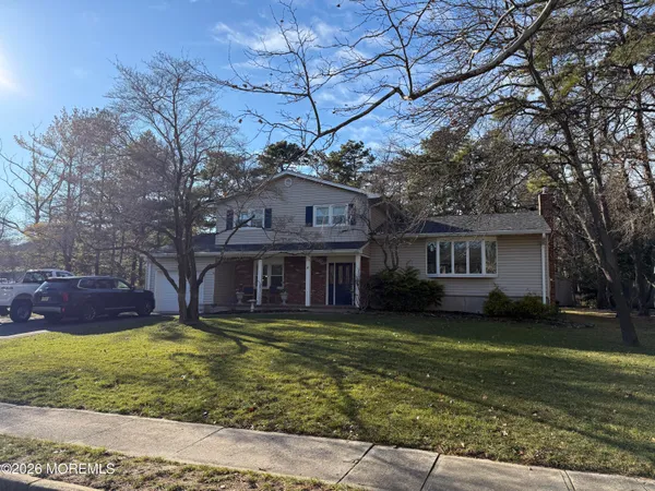 a view of a house with a big yard and large tree