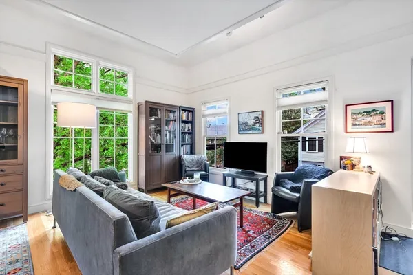 a living room with furniture a bookshelf and a flat screen tv