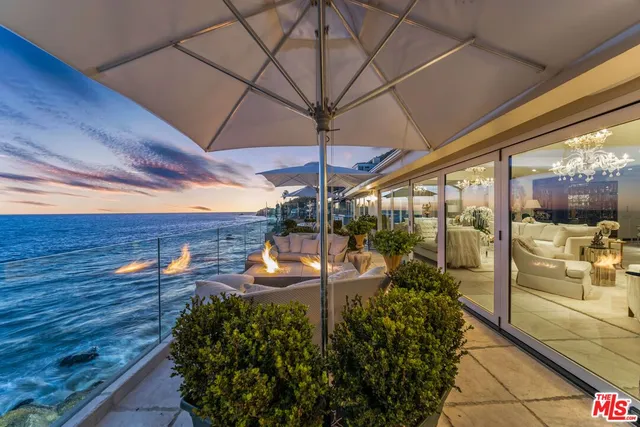 a view of a patio with a dining table and chairs under an umbrella