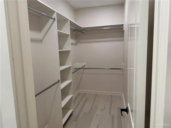 a view of walk in closet with empty racks