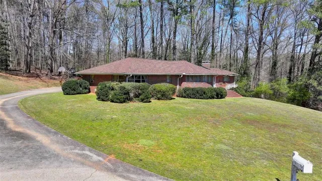 a front view of a house with yard and green space