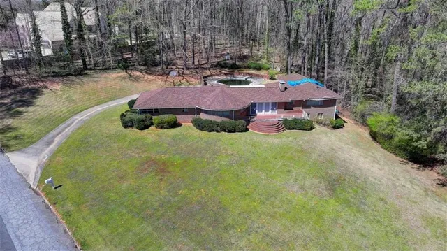 a view of backyard with swimming pool and outdoor seating