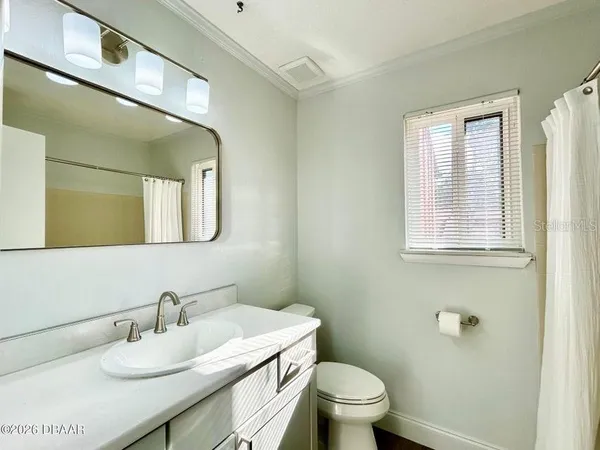 a bathroom with a granite countertop sink a toilet and a mirror