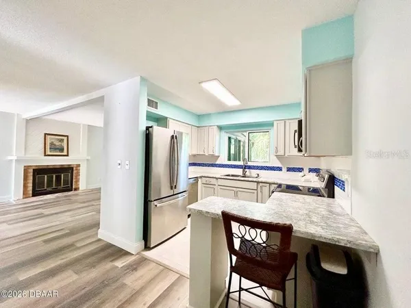 a kitchen with stainless steel appliances granite countertop a dining table and chairs