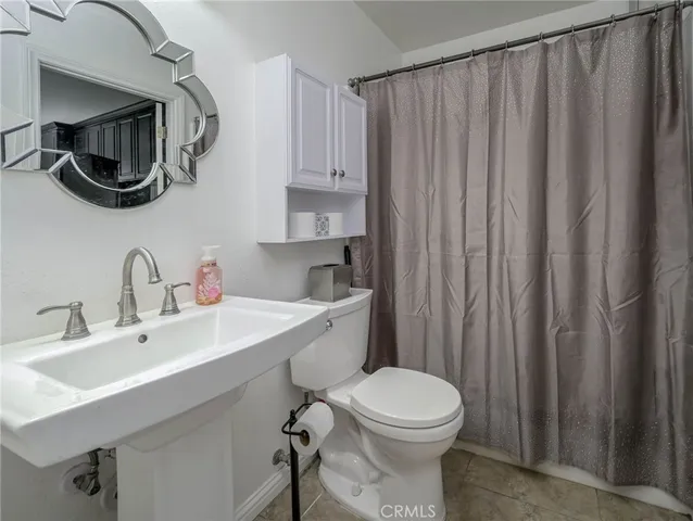 a bathroom with a toilet a sink and curtain