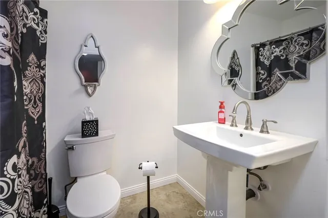 a bathroom with a sink a toilet and mirror