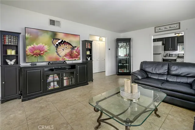 a living room with furniture a flat screen tv and a wall painting