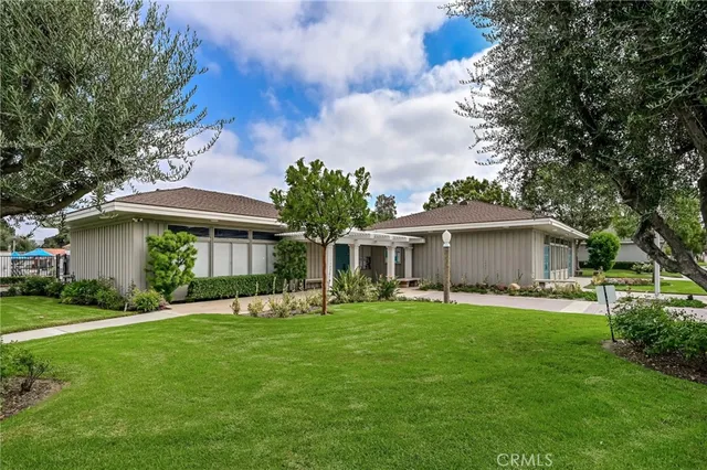 a front view of a house with a garden and trees