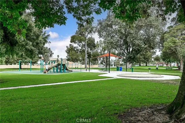 a view of grassy field with benches and trees all around