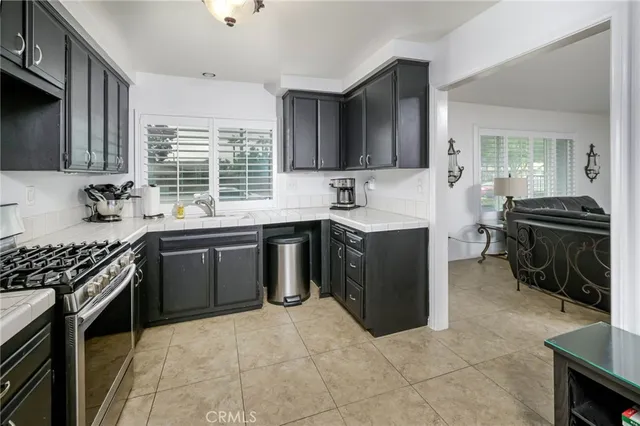 a kitchen with a sink stove top oven and cabinets