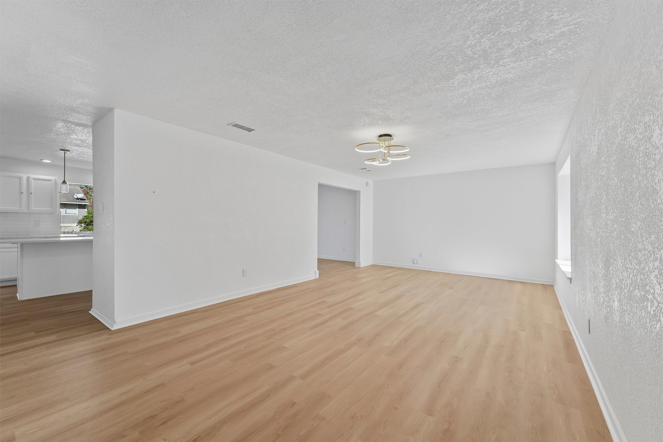 3223 Deer Valley Drive Spring, TX 77373 - Photo 4 of 25 a view of an empty room with wooden floor and a kitchen